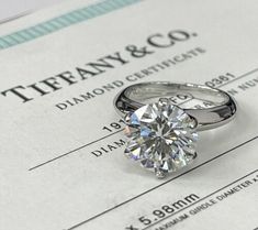 a diamond ring sitting on top of a certificate