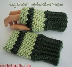 two crochet fingerless gloves made with green and white yarn, on top of a doll's head