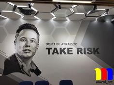 a wall with a painting of a man on it that says don't be afraid to take risk