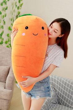 a woman hugging a giant stuffed carrot pillow