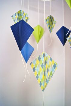 several colorful kites hanging from strings in a room