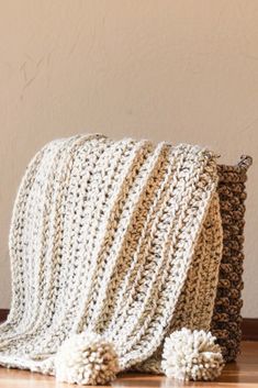 two crocheted bags sitting on top of a wooden table next to each other