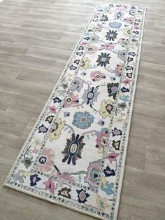 a long rug on the floor in a room with hardwood floors and white walls,