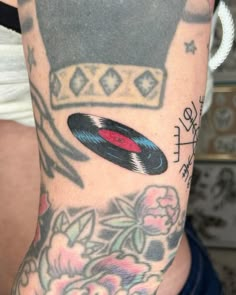 a man with a tattoo on his arm has an old record in the middle of it