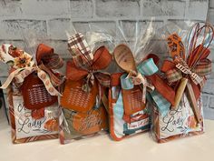 four bags with wooden spoons in them and some ribbons tied around them on a table