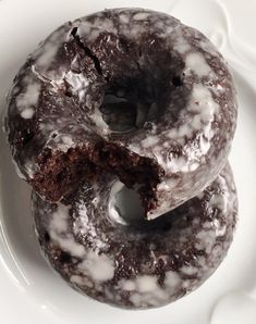 two chocolate donuts on a white plate