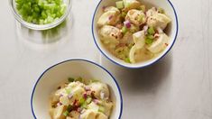 two bowls filled with food sitting on top of a white table next to a bowl of celery