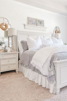 a white bed sitting in a bedroom on top of a carpeted floor next to a dresser