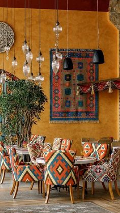 a dining room filled with lots of colorful chairs and tables next to a potted plant