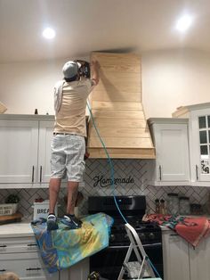 a man is painting the ceiling in his kitchen