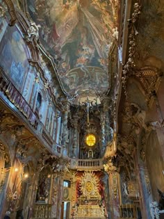 the interior of an ornately decorated church with paintings on the walls and ceiling,