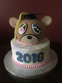 a graduation cake with a teddy bear on it's head and the number 2013