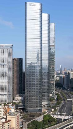 an aerial view of two skyscrapers in the city with cars driving on the road