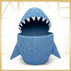 a blue basket with a shark's teeth on the front and bottom, sitting in front of a white background