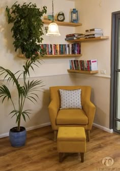 a yellow chair sitting in front of a window next to a potted plant