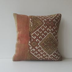 an orange and brown pillow sitting on top of a white wall