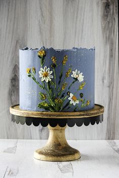 a blue cake with white flowers on it