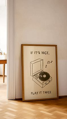 an old record player is on the floor next to a framed poster that says if it's nice, play it twice