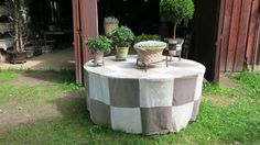 an outdoor table with potted plants on it