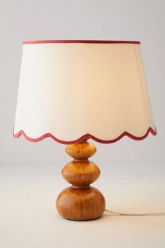 a lamp that is sitting on top of a wooden base with a white shade over it