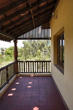 an empty balcony with red tile and wooden railings