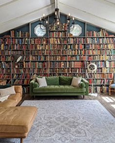 a green couch sitting in front of a book shelf filled with lots of different books