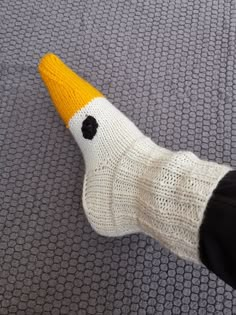 a persons foot wearing a knitted sock with an orange and white bird on it