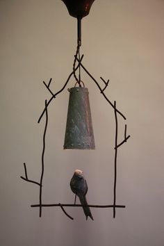 two birds perched on branches under a light fixture