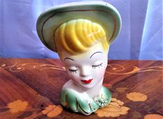 a ceramic figurine wearing a green hat on top of a table