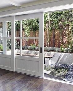 an empty room with sliding glass doors leading to a patio and trees in the background