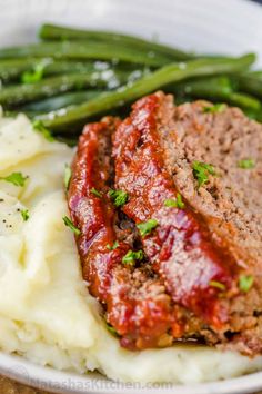 meatloaf, mashed potatoes and green beans in a white bowl on a wooden table