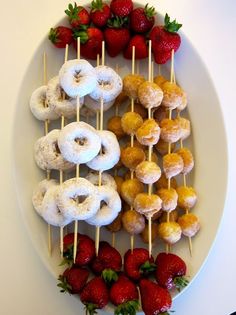 strawberries and donuts are arranged on skewers