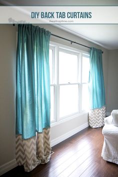 a living room with a white couch and blue drapes on the window sill