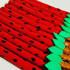 several red and green toothpicks with black dots on them are lined up next to each other