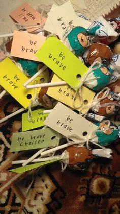 many different colored paper tags on top of some toothpicks with words written on them