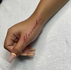 a woman's hand with a small tattoo that reads, be kindred on it