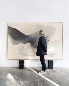 a person standing in front of a large painting