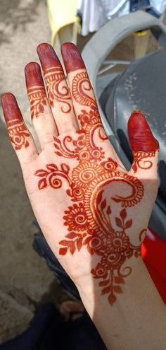 the hand is decorated with red henna