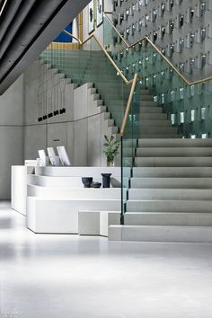 a staircase with glass railings leading up to the top floor and below it is a set of stairs