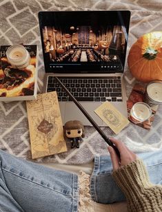 a person sitting on a bed with a laptop and harry potter memorabilia in front of them