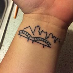 a wrist tattoo with a city skyline on it