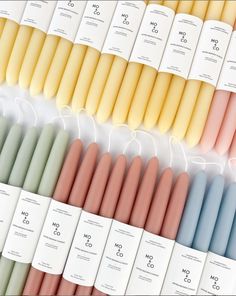 many different colored candles are lined up in the same row and each is labeled with an individual's name