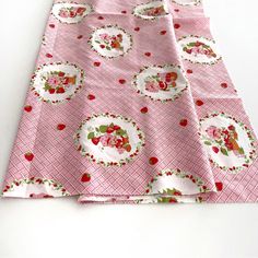 the table cloth has strawberrys and cherries on it