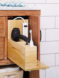 an electronic device is plugged into a drawer in a bathroom with white tiles on the walls