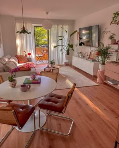 a living room filled with furniture and a flat screen tv on top of a wooden floor