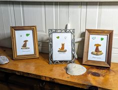 three framed pictures on top of a wooden table next to a seashell and sea shell