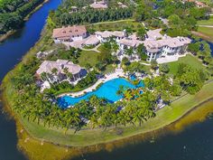 an aerial view of a large estate with a pool and palm trees in the foreground