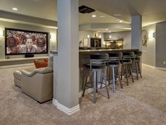 this is an image of a home theater with bar and seating area in the basement