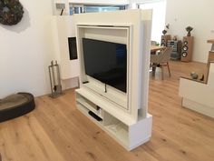 a flat screen tv sitting on top of a white entertainment center in a living room