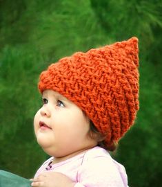 a small child wearing an orange knitted hat